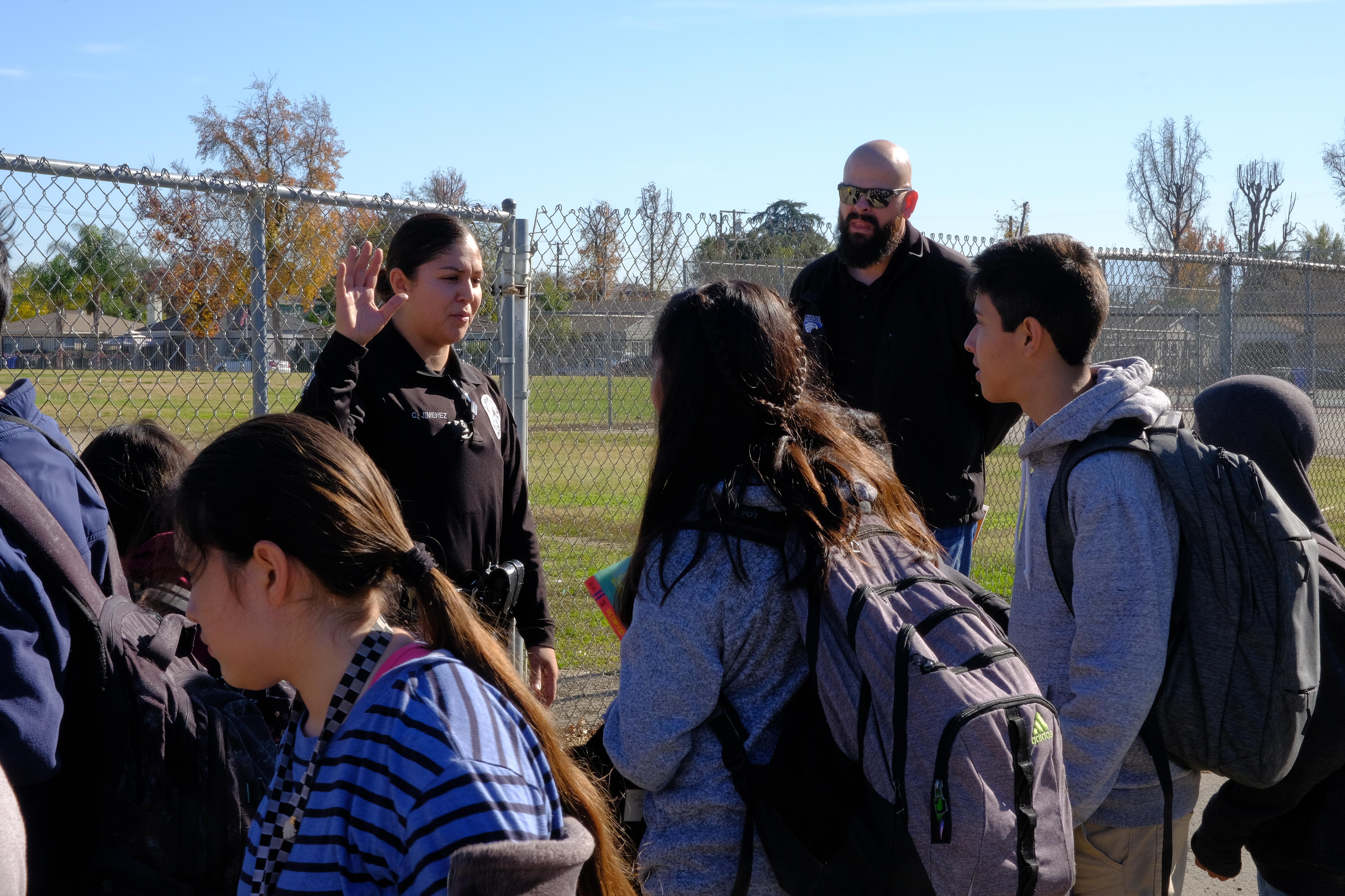 officer Jimenez talking to students waiting for PD Hellicopter